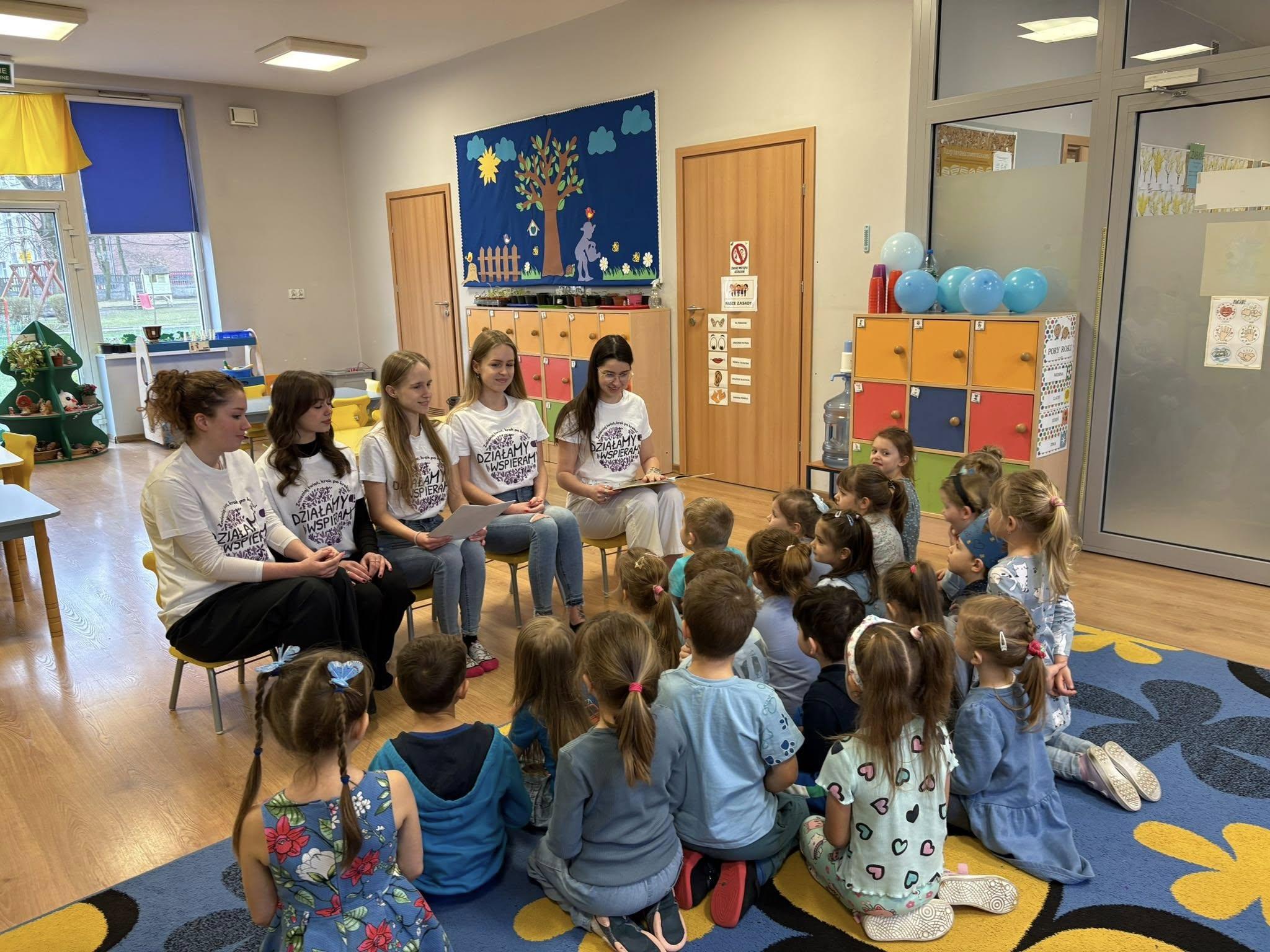 Female volunteers lead activities with children in a preschool as part of the project.