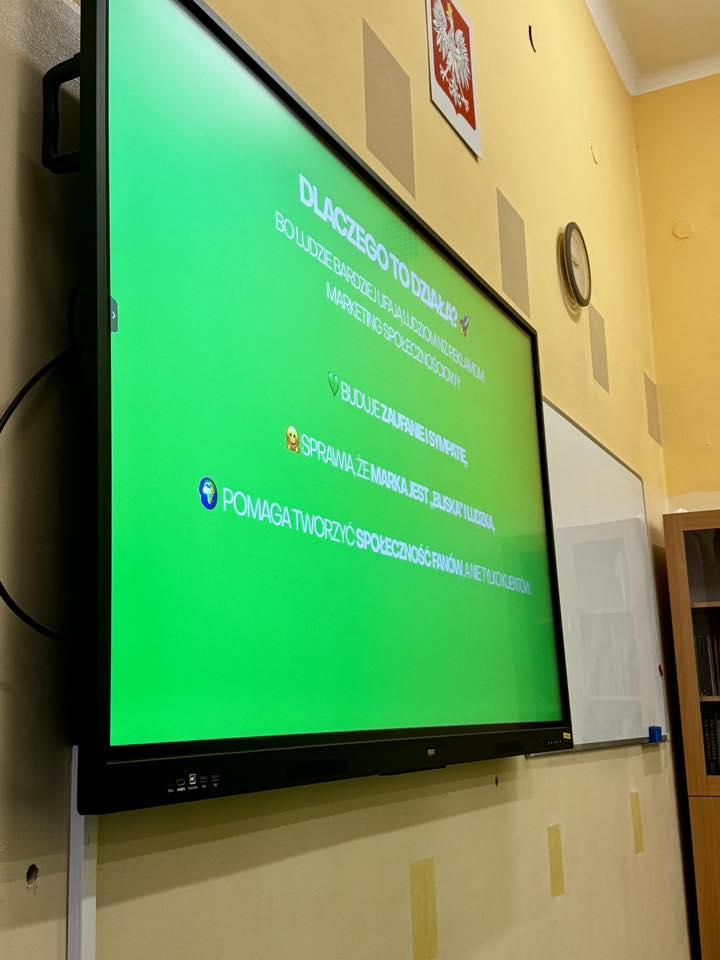Participants sit at a table with workshop materials and a tablet during a session.