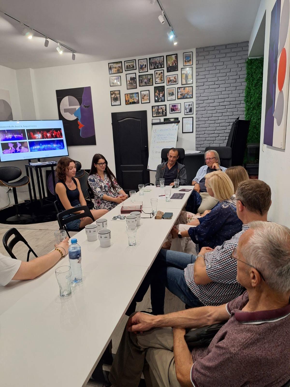 Participants in the Polish–Norwegian meeting seated together around a table during a presentation