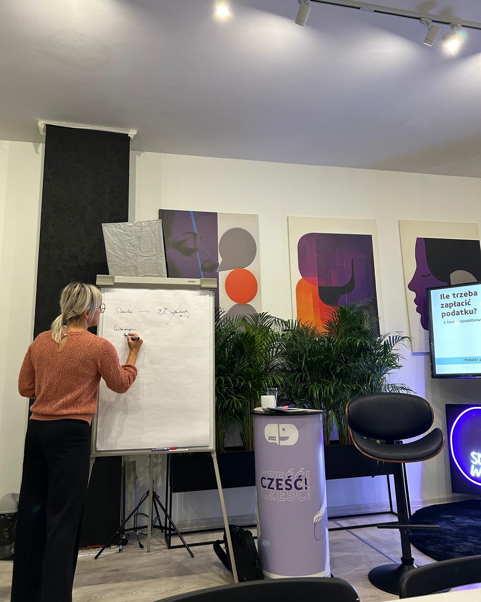 A workshop participant takes notes on a flip chart in the “Słowem w twarz” project room.