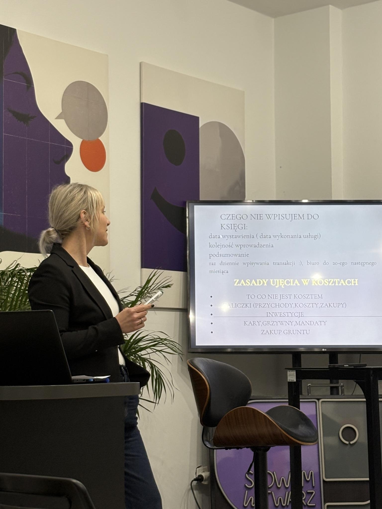 Meeting participants sit at a conference table during a presentation in the project room.