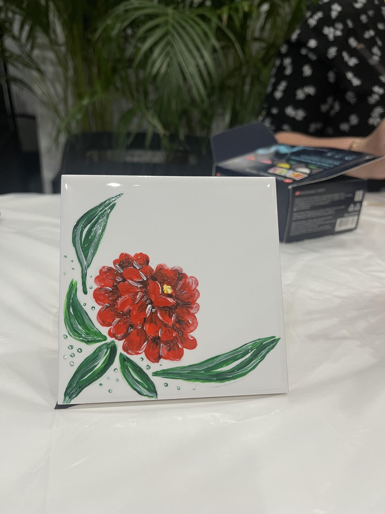 Participants document an art project on a tablet during creative workshops.