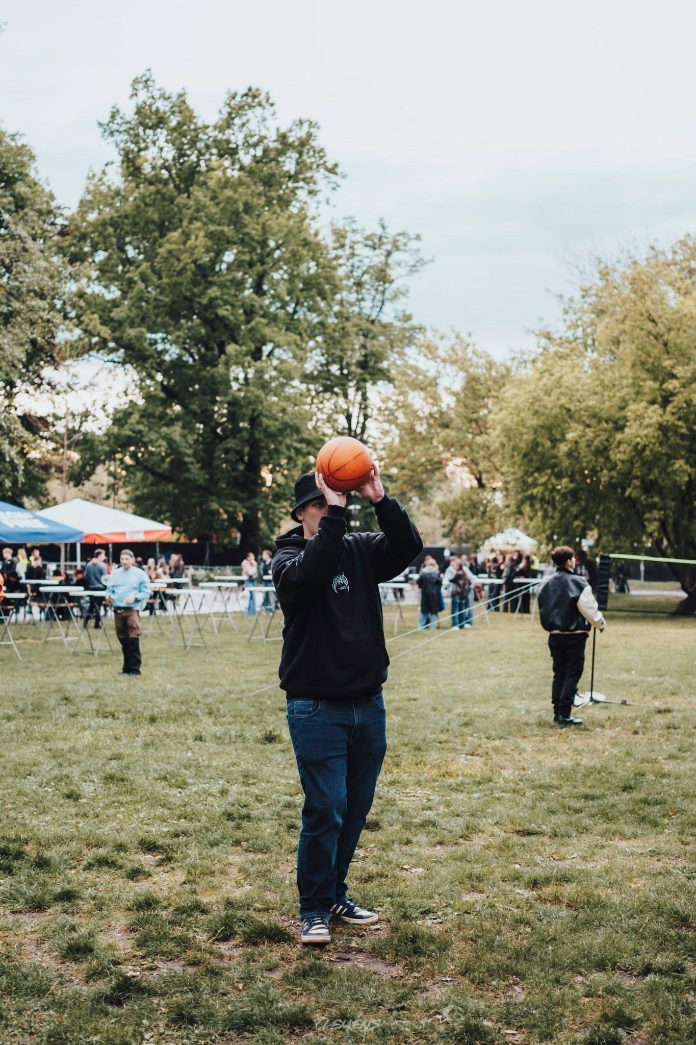A participant shooting a basketball in the outdoor sports zone
